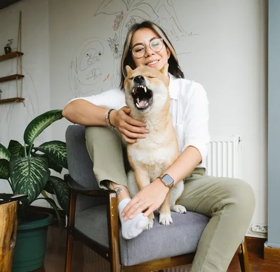 An owner sitting with her dog on her lap